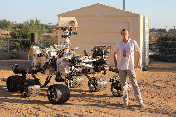 Астрофизик Алексей Вареников позирует рядом с марсоходом Curiosity 