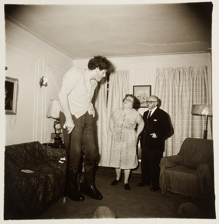 Диана Арбус. Это Эдди Кармел, еврей-гигант с родителями в гостиной их дома в Бронксе. США, 1970